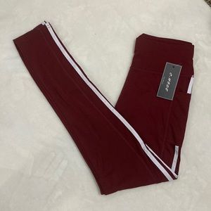 C-mode Burgundy leggings with Two white lines down outside of legs. Hip pockets